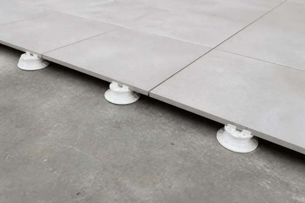 Carrelage gris clair posé sur plots réglables blancs