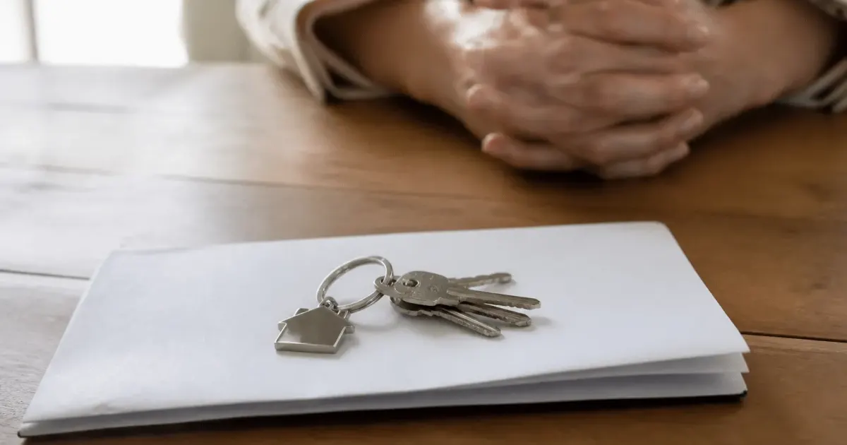 Document notarié posé sur table avec clés maison