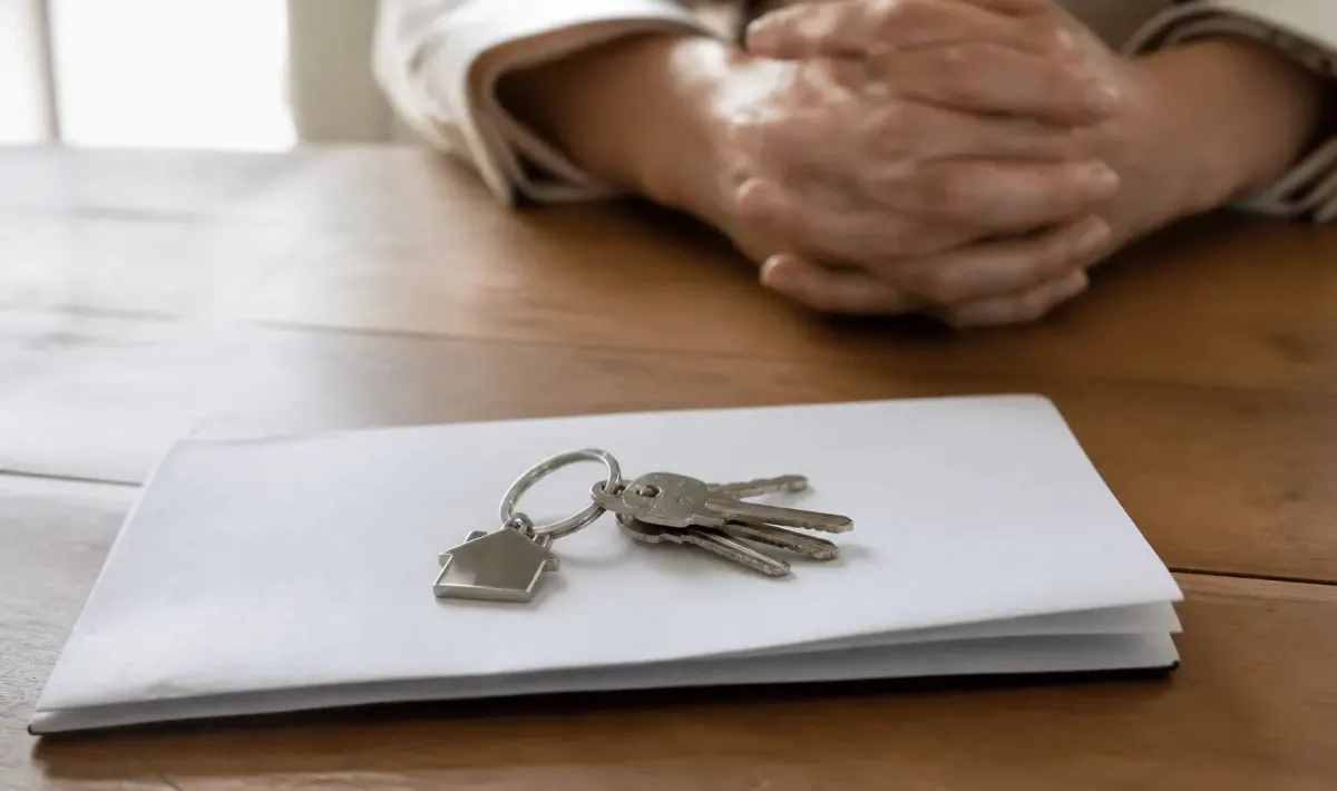 Document notarié posé sur table avec clés maison