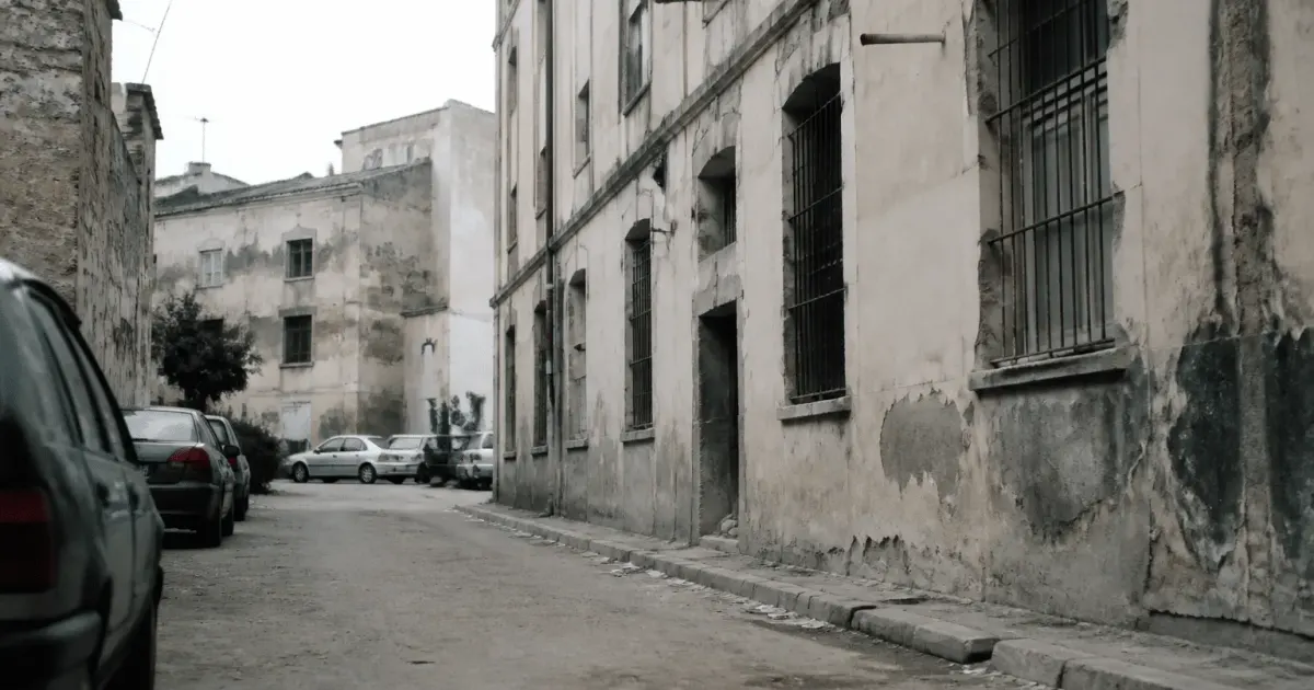 Rue urbaine degradee avec immeubles anciens et facades ternies