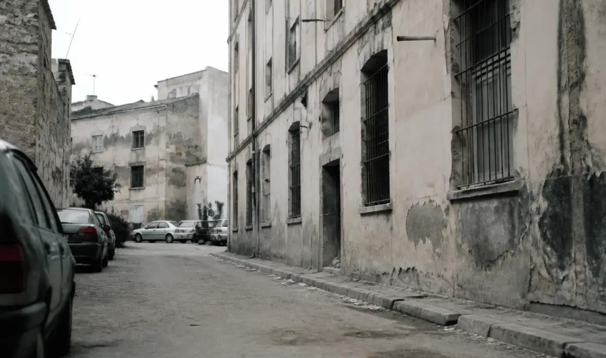 Rue urbaine degradee avec immeubles anciens et facades ternies