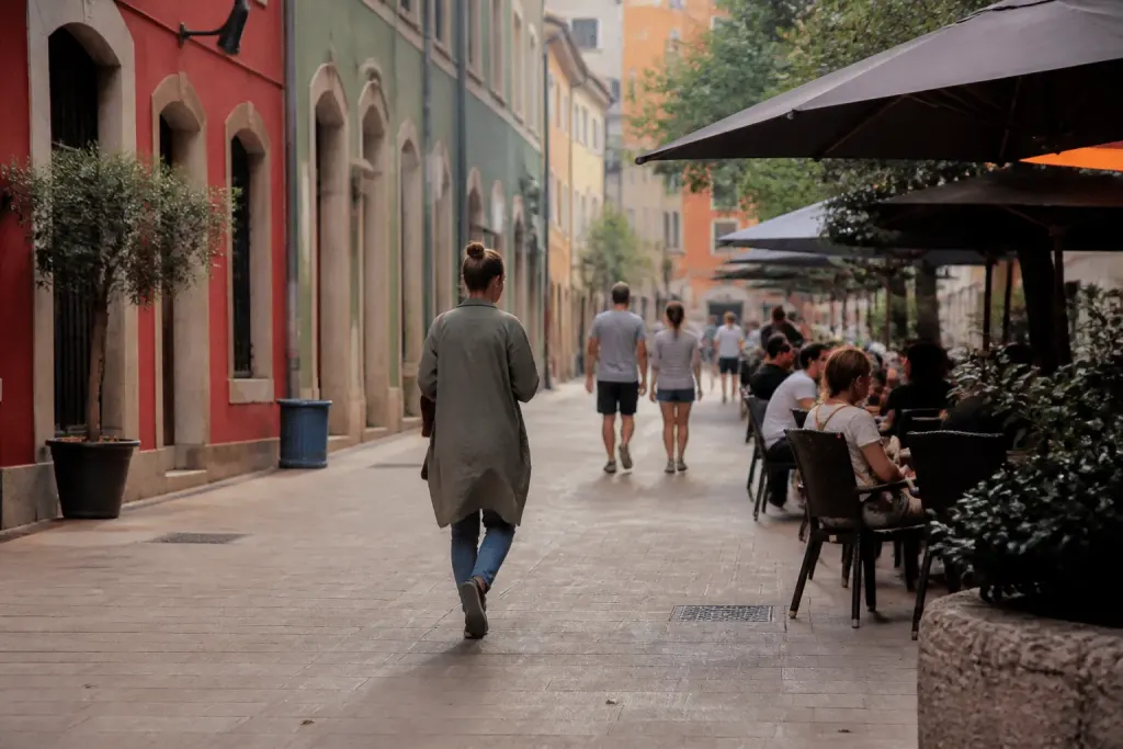 Rue piétonne animée avec façades colorées et terrasses accueillantes