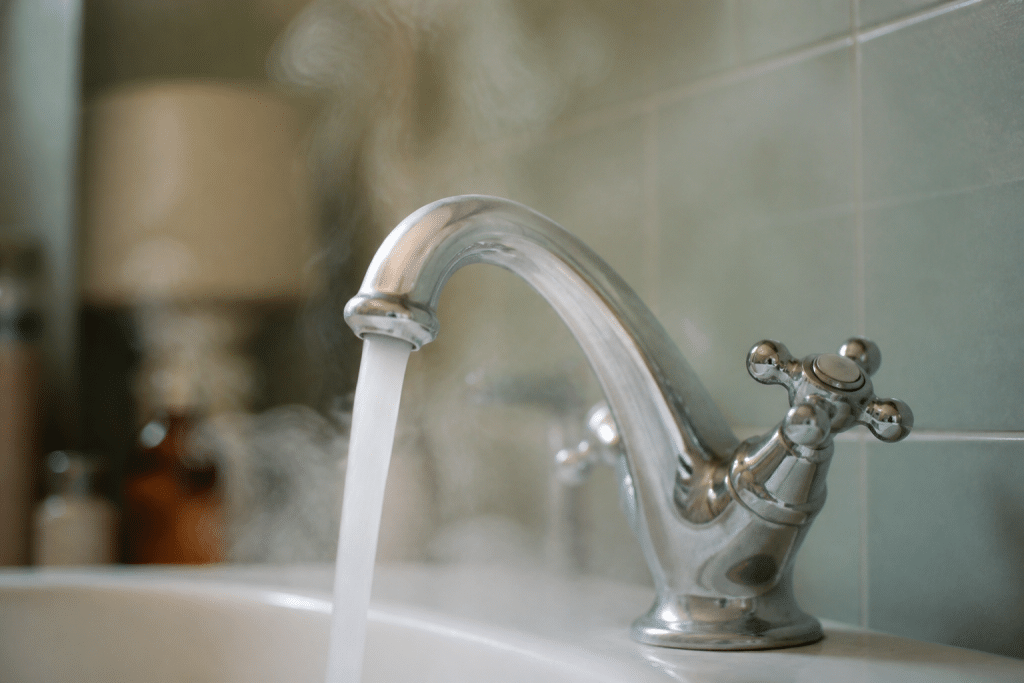 Robinet eau chaude ouvert avec vapeur visible sortant