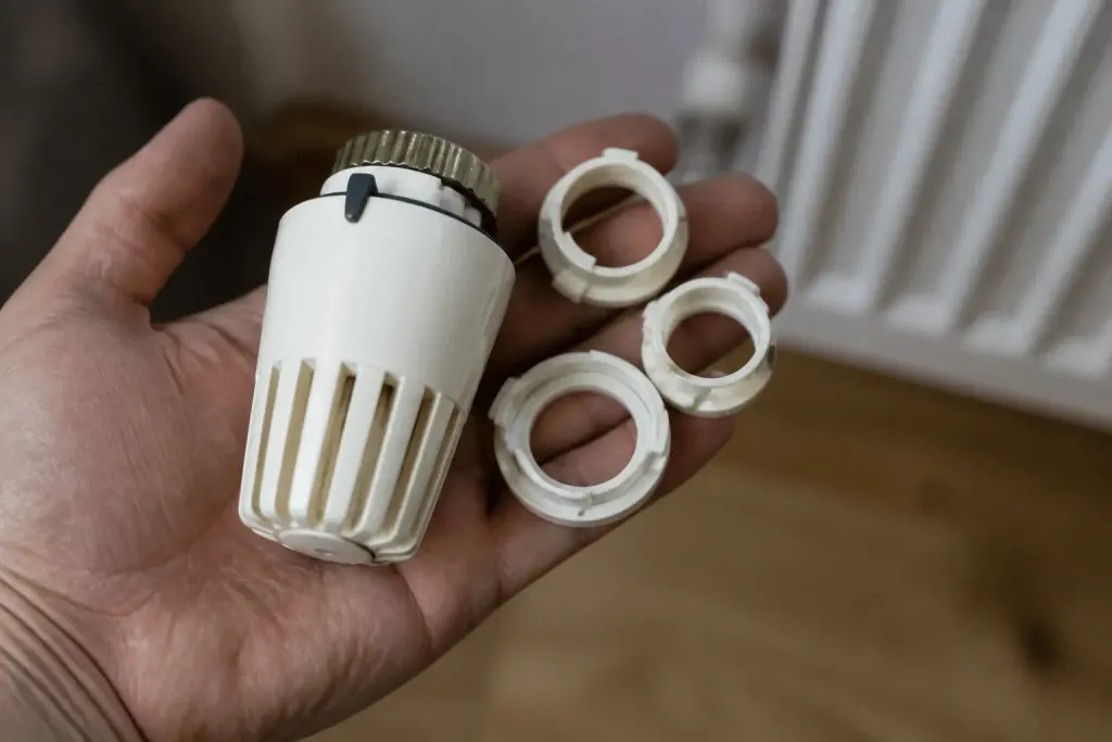 Main tenant tête thermostatique avec trois systèmes fixation visibles