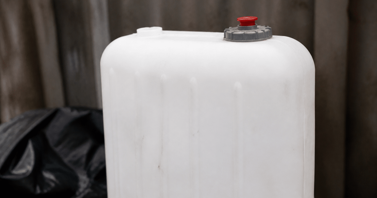 Grand reservoir blanc vertical avec bouton rouge arme en haut