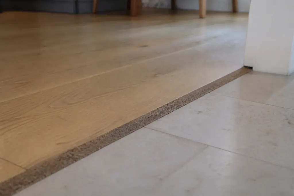 Bande de liege brune entre parquet chene et carrelage