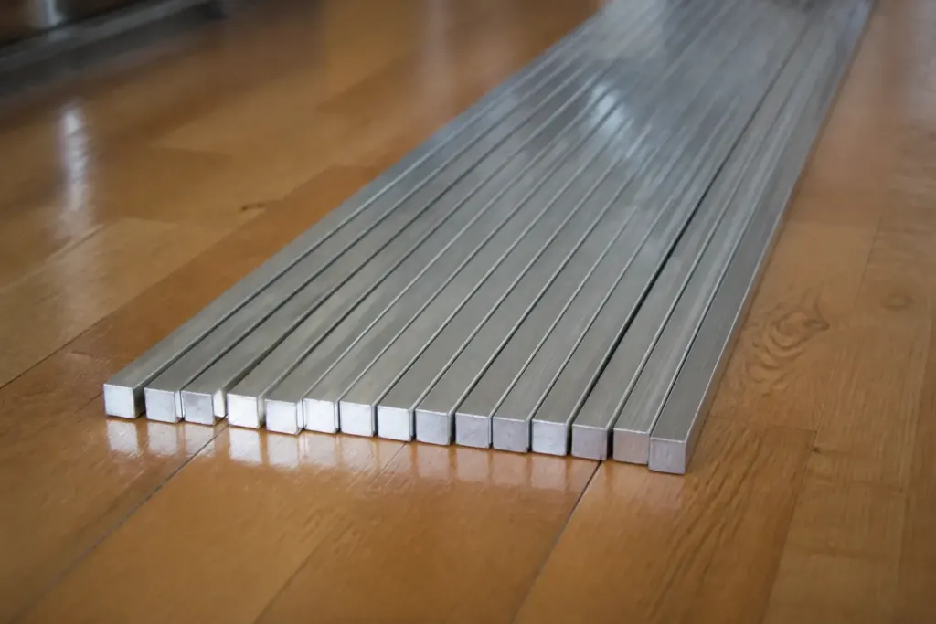 Barres aluminium brossees alignees sur parquet massif