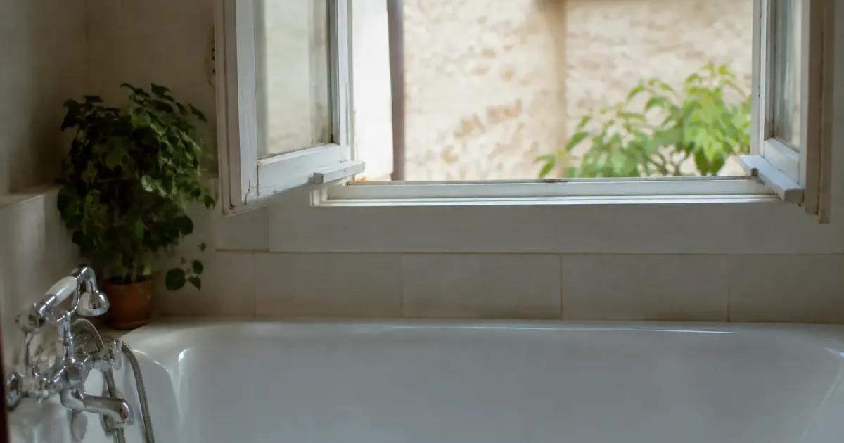 Fenetre entrouverte au dessus d une baignoire blanche