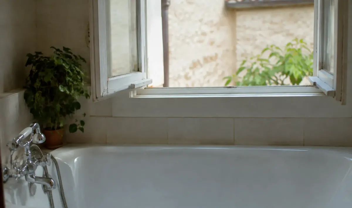 Fenetre entrouverte au dessus d une baignoire blanche
